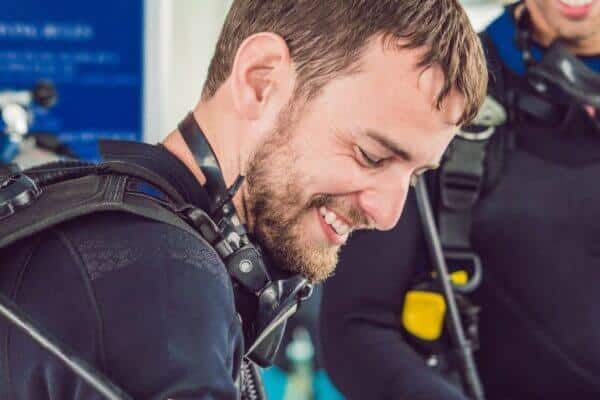 Lachender Taucher mit schwarzer Maske um den Hals