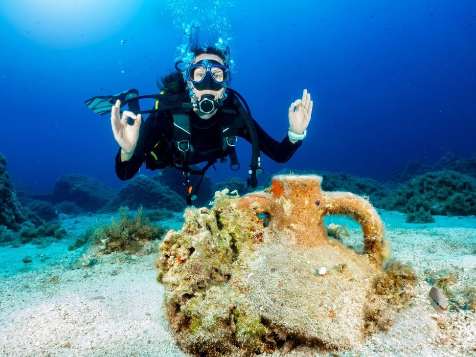 Taucher mit OK Zeichen über Krug