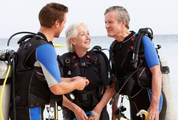 Divemaster beim Briefing von zwei Altern Menschen